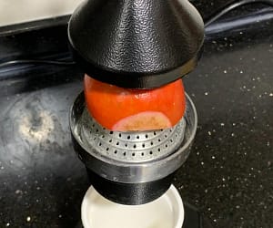 put_pomegranate_in_hand_press_juicer