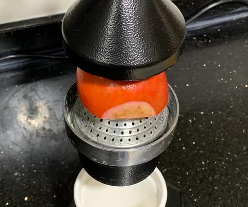put_pomegranate_in_hand_press_juicer